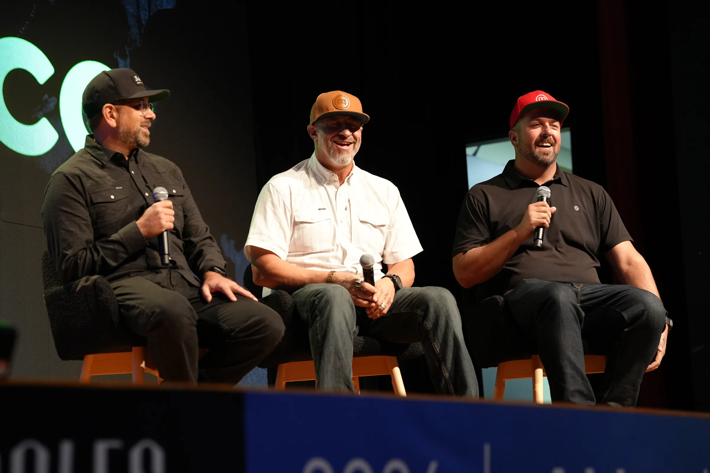 Three members of the MAGNETIC team speaking on stage during a panel discussion